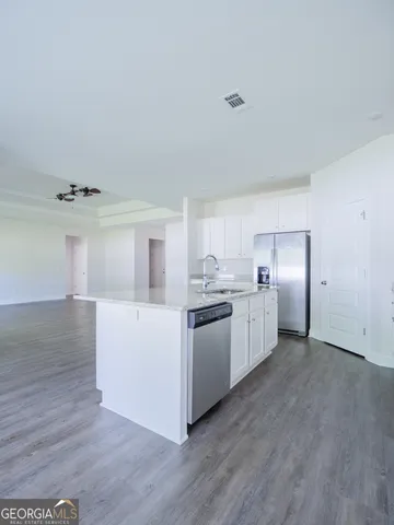 a kitchen with granite countertop white cabinets and white appliances