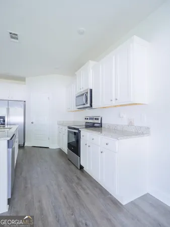 a kitchen with granite countertop stainless steel appliances refrigerator and cabinets