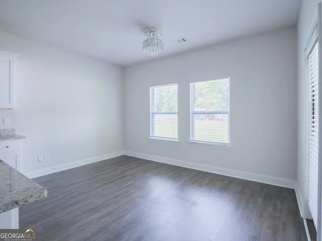 a view of a kitchen with wooden floor and electronic appliances
