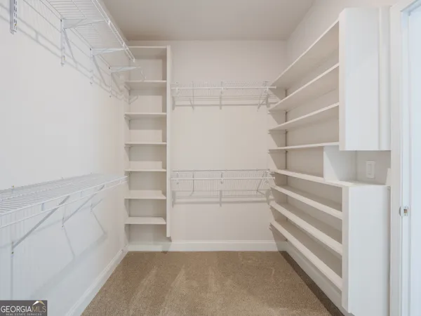 a view of walk in closet with empty racks