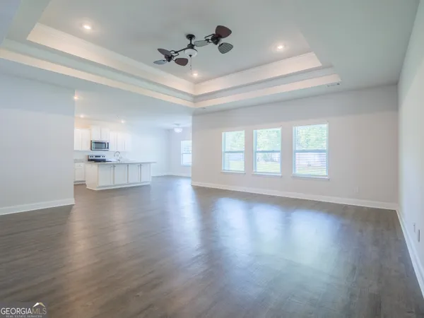 a view of a kitchen with wooden floor and electronic appliances