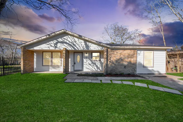 a front view of a house with a garden and yard