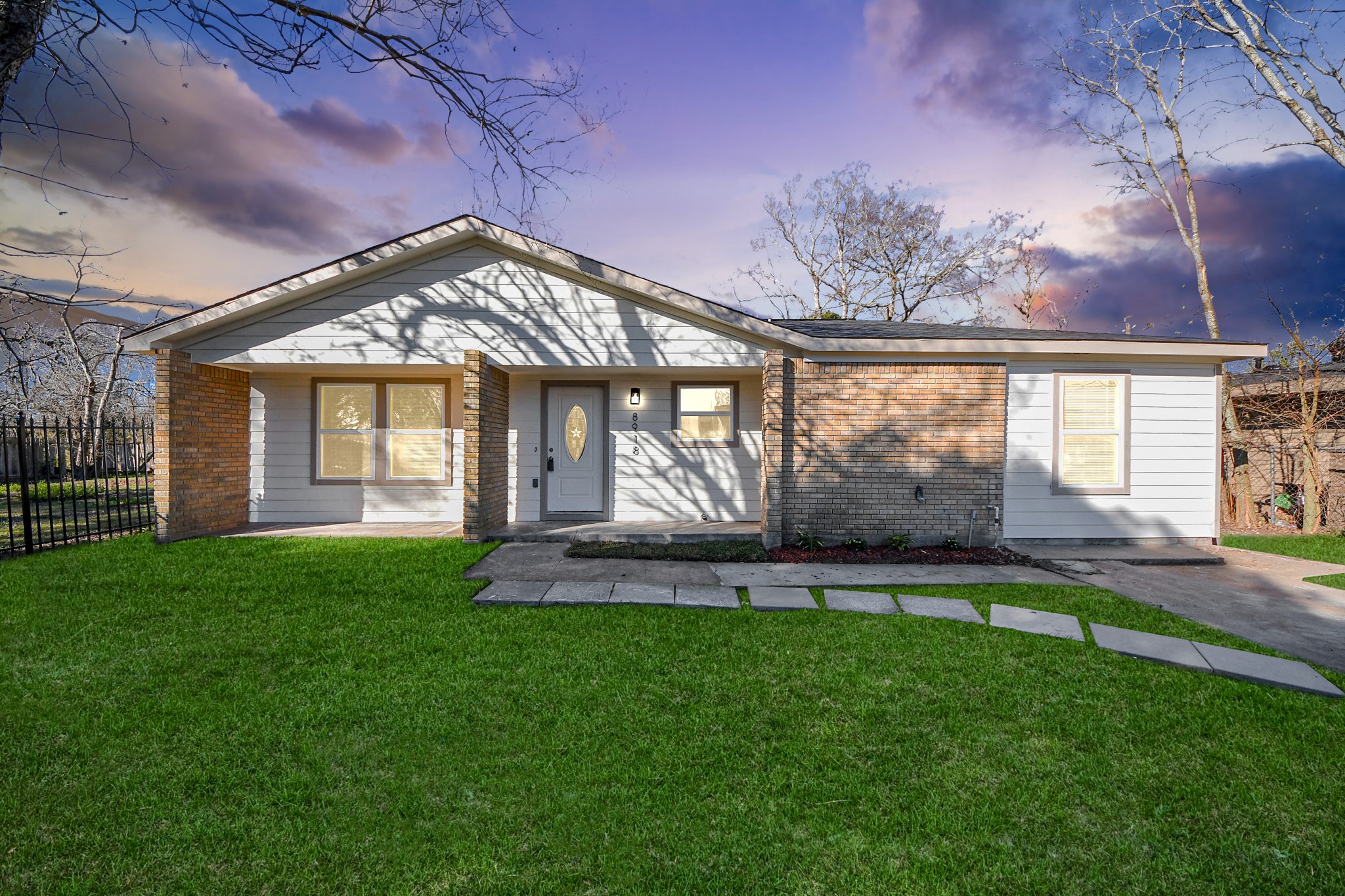 a front view of a house with a garden and yard