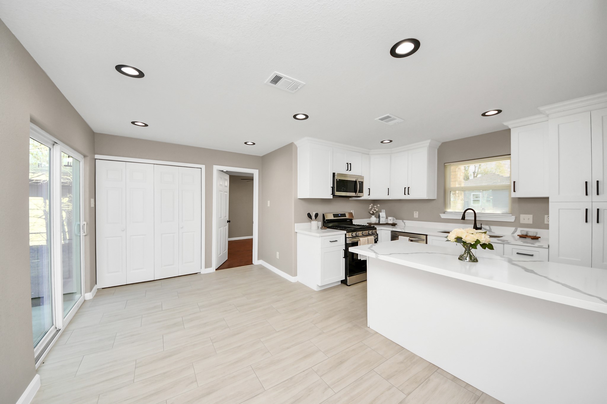 8918 Vinearbor Street Houston, TX 77033 - Photo 20 of 35 a kitchen with stainless steel appliances a sink a stove a refrigerator cabinets and living room view