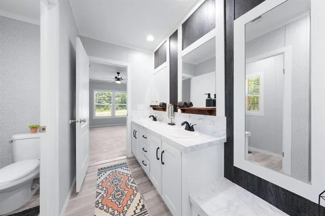 a spacious bathroom with a double vanity sink mirror and toilet