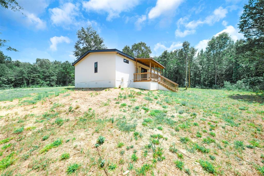 211 3900th Road Gilmer, TX 75644 - Photo 30 of 30 a backyard of a house with large trees and plants