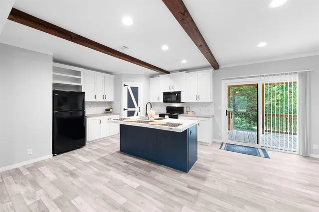 a large kitchen with kitchen island a sink stainless steel appliances and cabinets