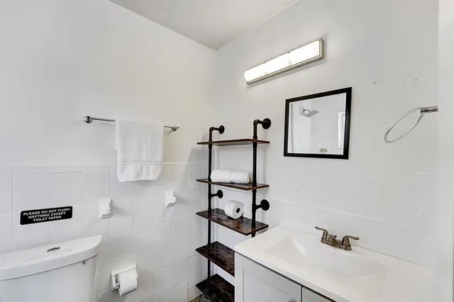 a bathroom with a sink a toilet and mirror