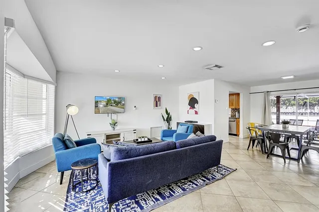 a living room with furniture a rug and a large window
