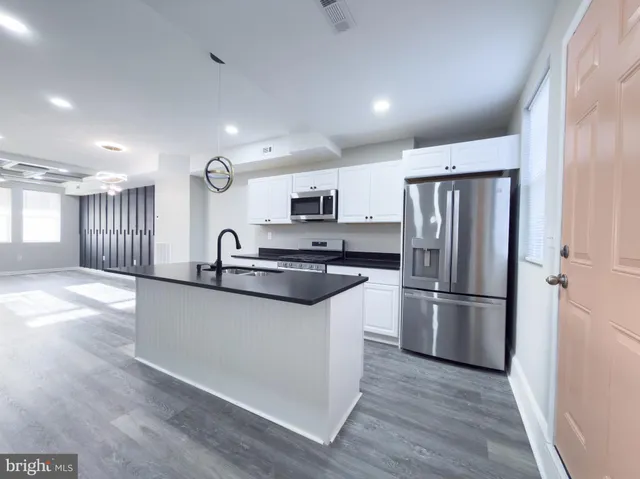 a kitchen with granite countertop a refrigerator and a sink