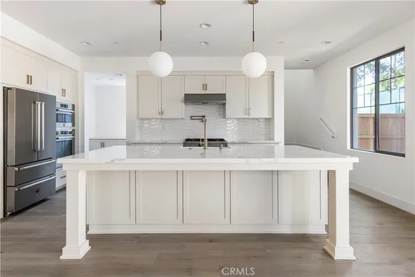 a kitchen with a white center island and cabinets