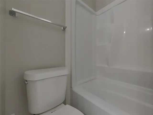 a white toilet sitting next to a bath tub
