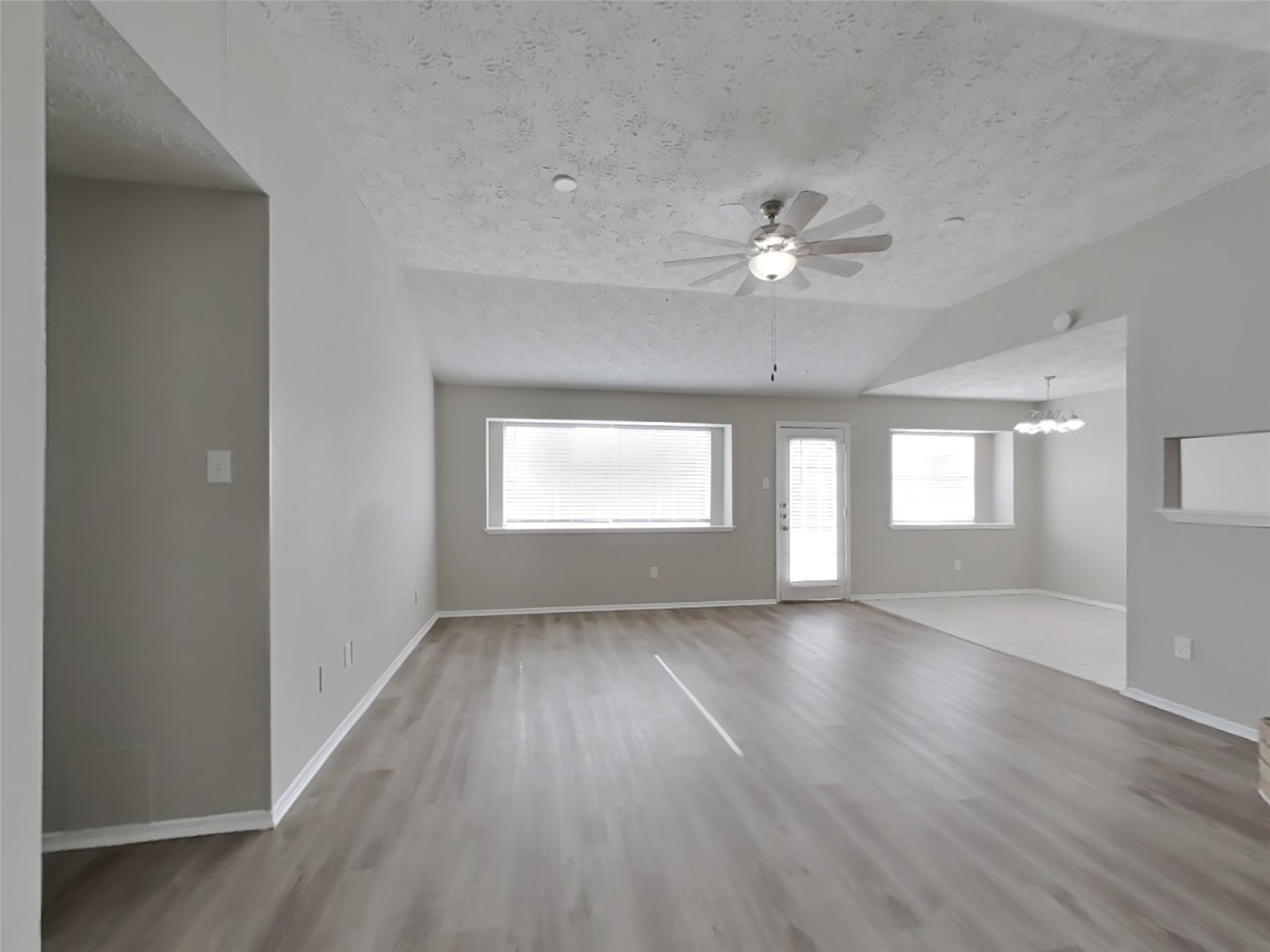 2802 North Spring Drive Spring, TX 77373 - Photo 4 of 19 an empty room with wooden floor chandelier fan and windows