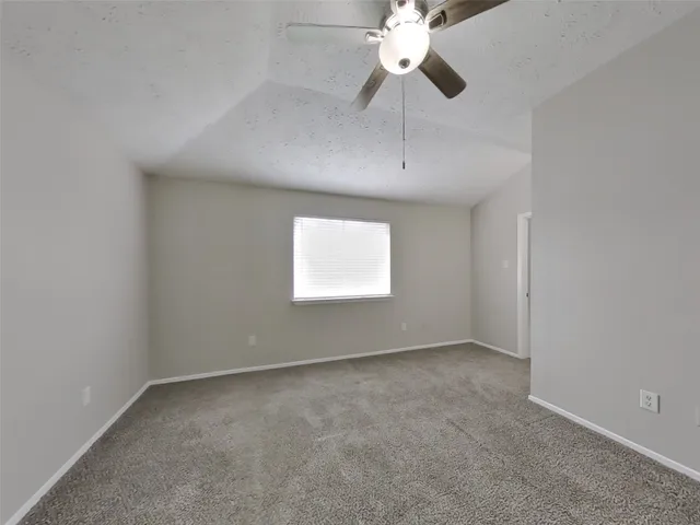 an empty room with a window and a fan