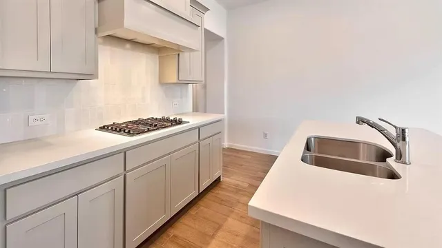 a kitchen with granite countertop a sink a stove and cabinets