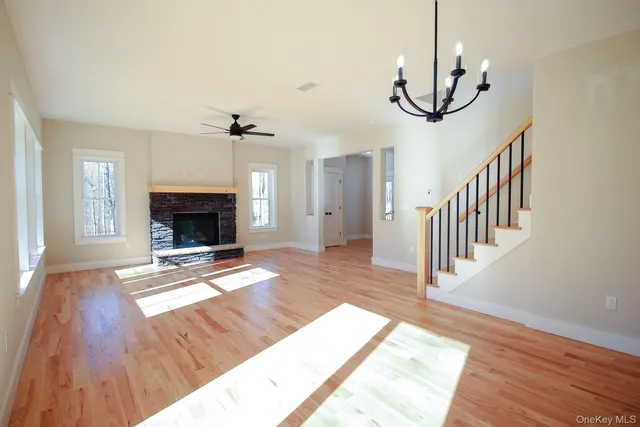 a view of a livingroom with wooden floor and staircase