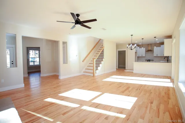 a view of a livingroom with wooden floor and a ceiling fan