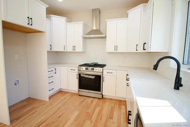 a kitchen with white cabinets and appliances