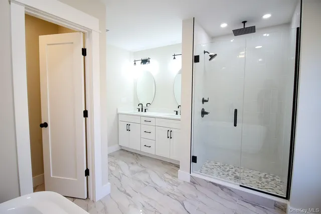 a bathroom with a double vanity sink and mirror with window