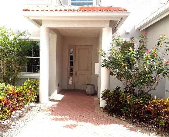 a view of a house with a small yard and potted plants
