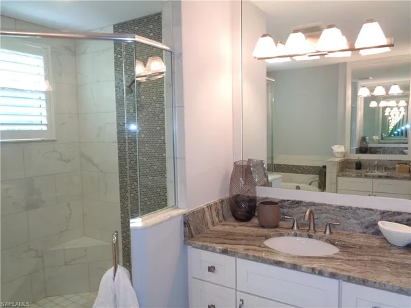 a bathroom with a granite countertop sink and a mirror