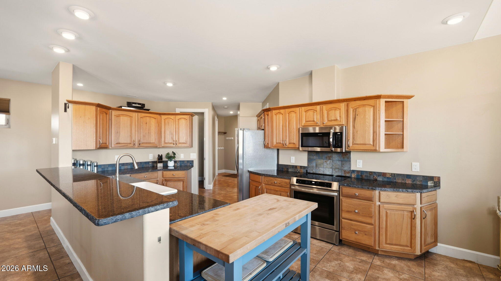 9630 North Aldrich Road Flagstaff, AZ 86004 - Photo 13 of 47 a kitchen with granite countertop a stove a sink a refrigerator a counter top space and cabinets