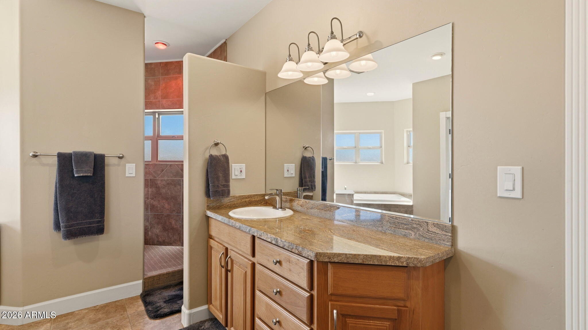 9630 North Aldrich Road Flagstaff, AZ 86004 - Photo 22 of 47 a bathroom with a granite countertop sink a large mirror and a shower