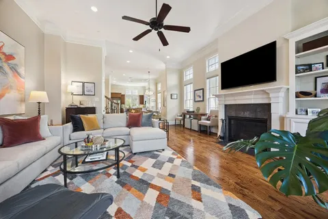 a kitchen with stainless steel appliances granite countertop a stove a sink a dining table and chairs with wooden floor