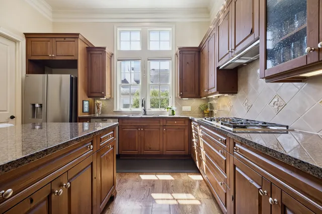 a kitchen with stainless steel appliances granite countertop a stove a sink and a refrigerator