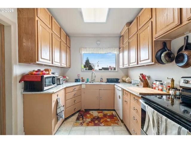 a kitchen with a sink window and cabinets
