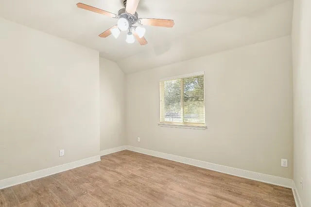 an empty room with windows and fan