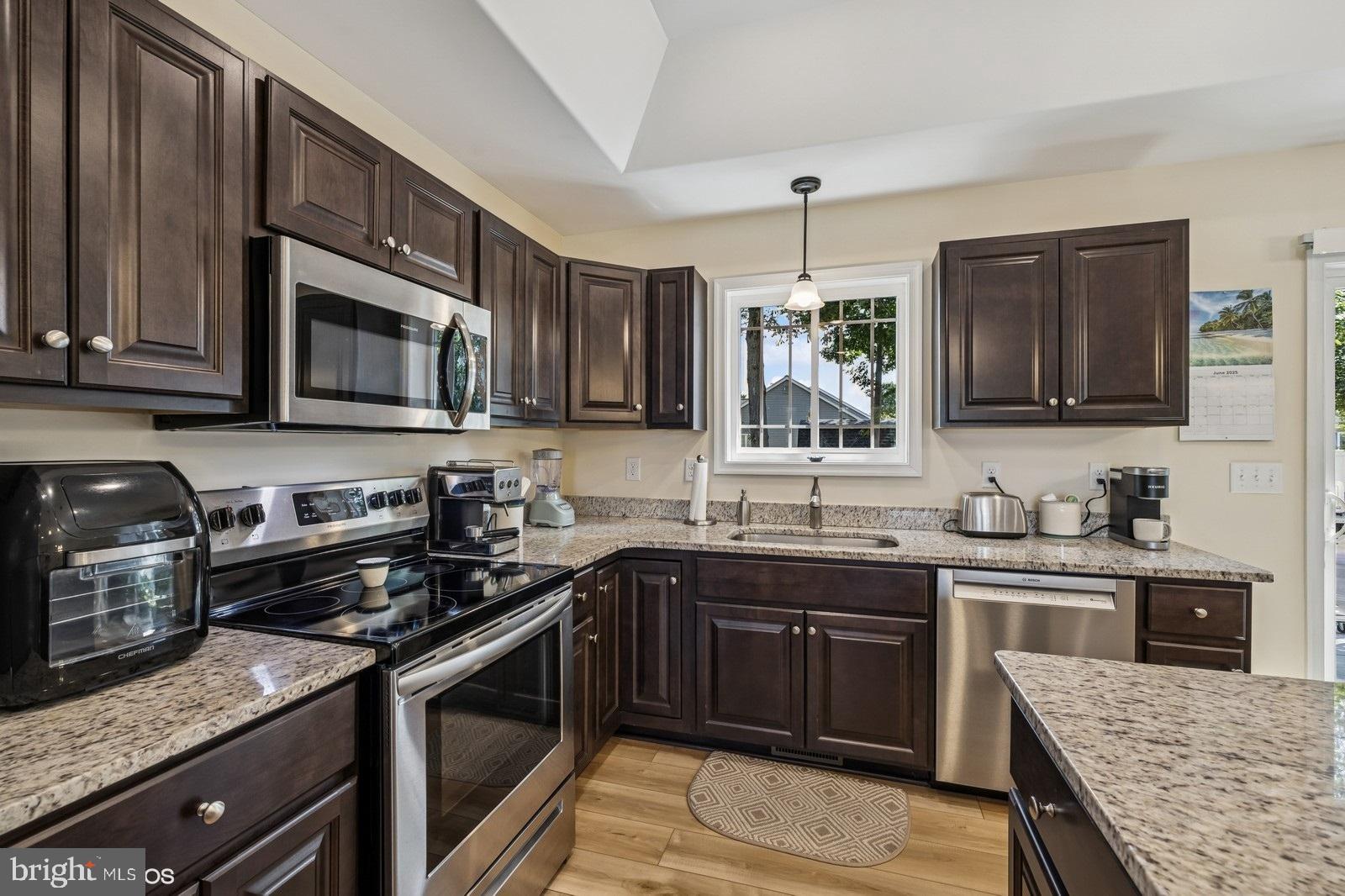 408 Summit Drive Seaford, DE 19973 - Photo 18 of 32 a kitchen with stainless steel appliances granite countertop a stove microwave and sink