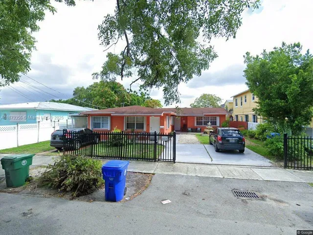 a front view of a house with a garden and fire pit