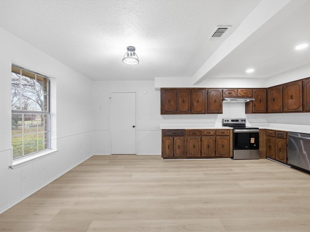 514 Dallas Street Italy, TX 76651 - Photo 15 of 34 a kitchen with stainless steel appliances kitchen island granite countertop a stove a sink and a refrigerator