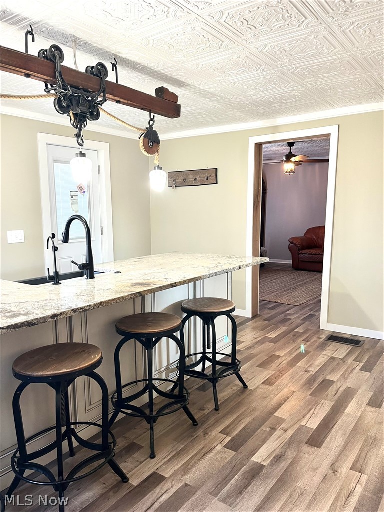 12972 Gilmore Road Southeast Port Washington, OH 43837 - Photo 15 of 50 Dining space featuring dark wood-style flooring, ornamental molding, ceiling fan, and an ornate ceiling