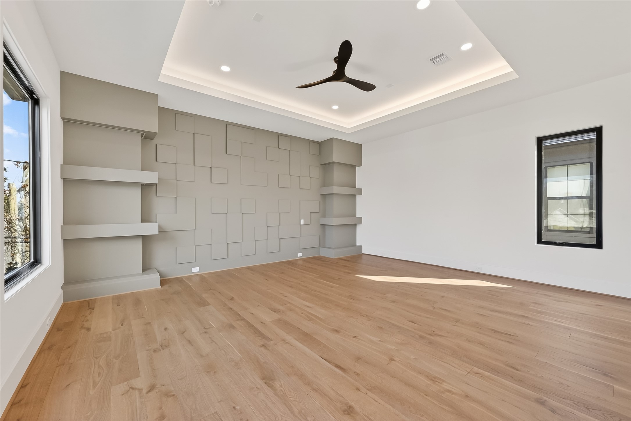 6534 Corbin Street Houston, TX 77055 - Photo 12 of 50 This luxurious primary suite features an accent designer wall with symmetrical shelves on both sides, and tray ceiling adding a tasteful touch of elegance and comfort.