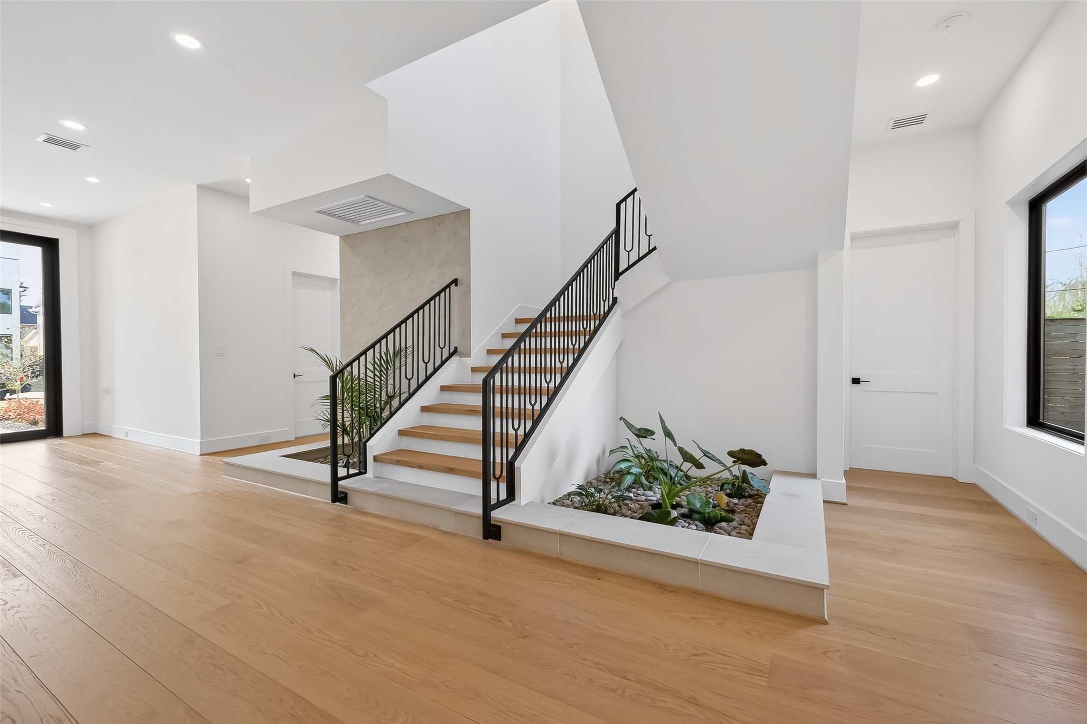6534 Corbin Street Houston, TX 77055 - Photo 2 of 50 Elegant foyer with iron railing staircase and indoor garden feature.