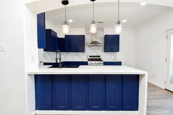 a kitchen with stainless steel appliances granite countertop a sink a stove a refrigerator and a wooden cabinets