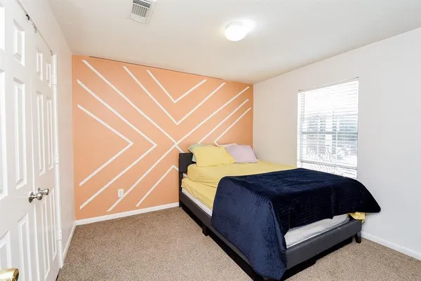 a bedroom with a bed and a window