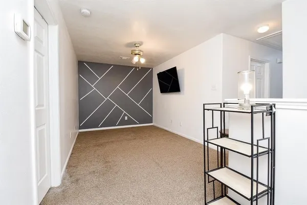an empty room with a flat screen tv and windows