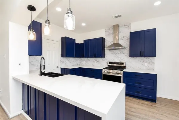 a kitchen with stainless steel appliances a stove a sink a refrigerator and cabinets