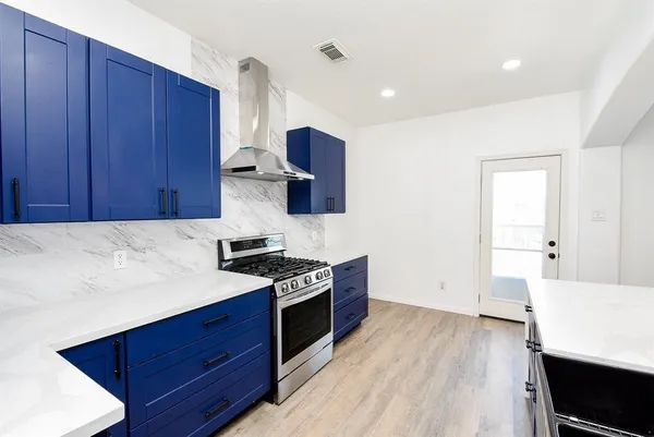 a kitchen with stainless steel appliances wooden cabinets and a stove top oven
