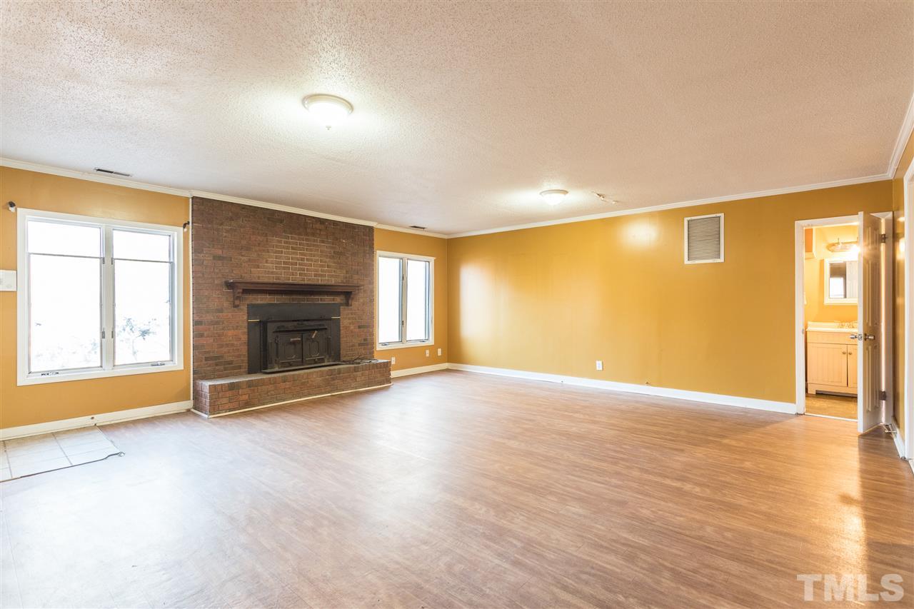 2004 Brocton Place Durham, NC 27712 - Photo 20 of 29 an empty room with wooden floor fireplace and windows