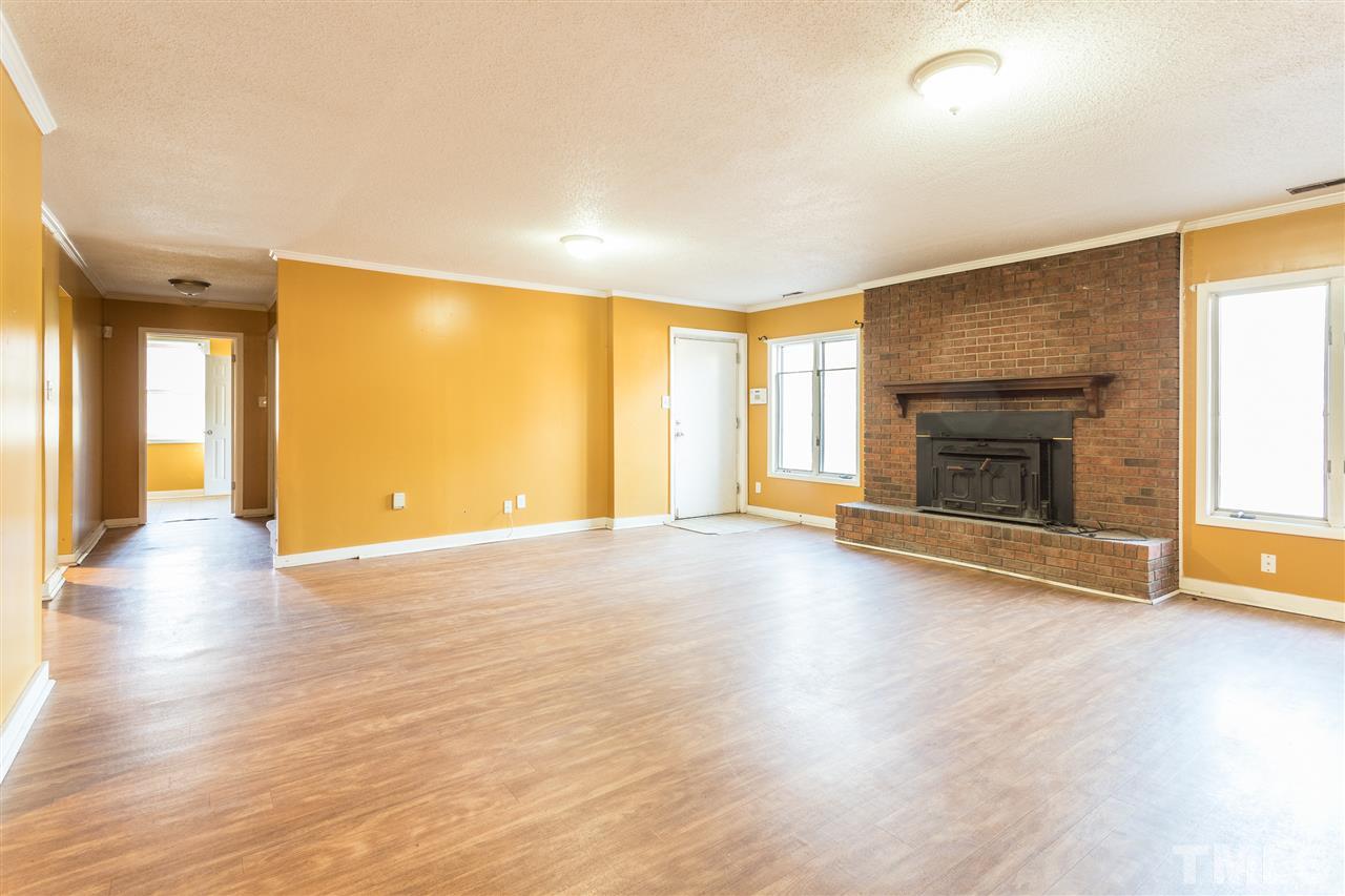 2004 Brocton Place Durham, NC 27712 - Photo 21 of 29 an empty room with wooden floor fireplace and windows