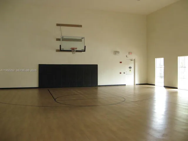 an empty room with a fireplace and wooden floor