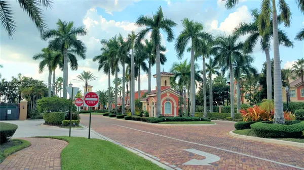 a view of a apartment with a yard and palm trees