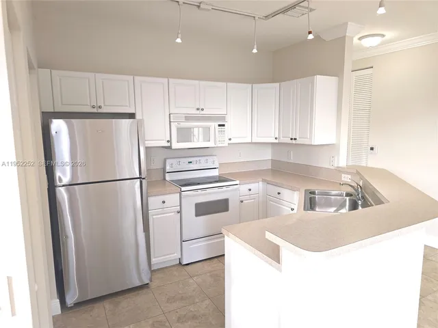 a kitchen with a refrigerator sink stove and cabinets