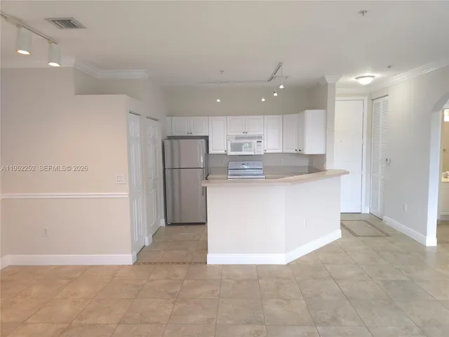 a view of kitchen cabinets and refrigerator