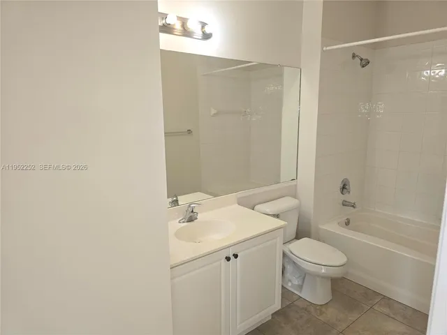 a bathroom with a white sink a toilet and shower