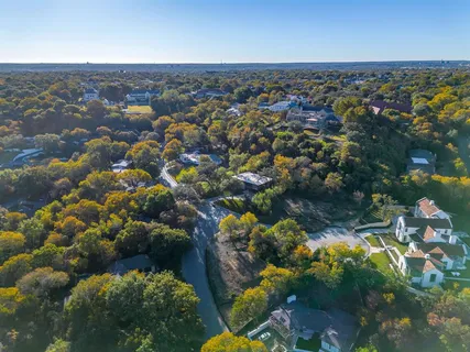an aerial view of residential houses with outdoor space and trees